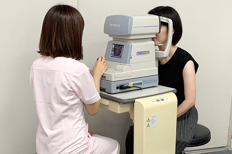 検査機器「オートケラトレフラクトメータ」で検査を受ける人の写真